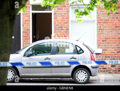 The battered front door of a property at the scene in Shildon, County Durham where a man was shot last night. Stock Photo