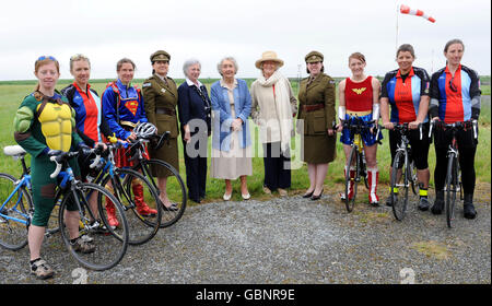 Currently serving soldiers, some in fancy dress gather with two members of the First Aid Nursing Yeomany (FANY) Tania Szabo, (5th left), daughter of French Resistance George Cross heroine Violette Szabo and two WWII veterans, Noreen Riols, (centre), who trained SOE members and Anne Ponsonby, who was an SOE and FANY s greet the Band of Brothers bike ride cyclist fundraising for Help for Heroes at Bernay Aerodrome, France on the fifth day of the 240 fundraising 350 mile route across France from Cherbourg to Paris which takes in some of the most significant WWII battle sites in a year which Stock Photo