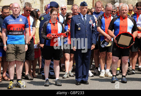 Former Royal Marine, John Gostick, 58, (right), from Oxfordshire, whose son Dale Gostick, 22, was killed serving with the Royal marines in Afghanistan one year ago today, accompanied by WO2 Andy Newell, (left), Colonel Mark Horn, US national military representative of SHAPE, (second right) and Amber Kilker, (second left), the sole US cyclist as they lay a wreath at the memorial to the 82nd Airborne Division, Ste Mere Eglise, northern France. Stock Photo