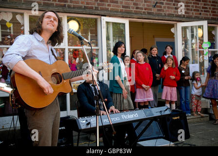 Neil Mullen of the Lowly Knights (left) rock band takes part in a special concert with pupils from Botanic Primary School, Belfast, to mark the school's 70th anniversary. Stock Photo
