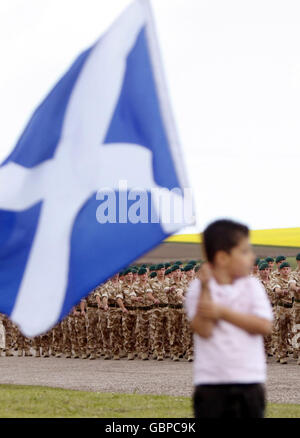 A boy waives the Scottish flag as members of 45 Commando Royal Marines, who recently returned from a tour of duty in Afghanistan, march through Arbroath during a homecoming parade. Stock Photo