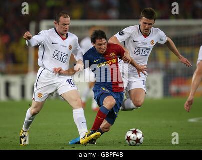 Barcelona's Lionel Messi (centre) battles for the ball with Manchester United's Wayne Rooney (left) and Michael Carrick. Stock Photo