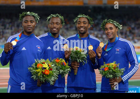 Great Britain's 4x100m relay team, Mark Lewis-Francis, Marlon Devonish, Darren Campbell and Jason Gardener celebrate with their gold medals Stock Photo