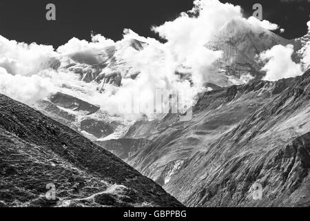 Snow covered mountain top engulfed in clouds. Stock Photo