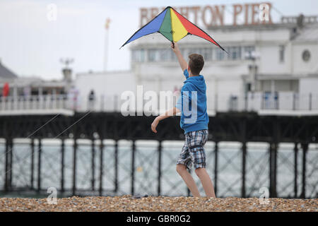 Brighton, UK. 7th July, 2016. A young boy flies a kite on Brighton beach as visitors to Brighton make the much of the fine weather with a warm weekend forecast with the warmest temperature's in a month predicted. 7th July 2016 Credit:  MARTIN DALTON/Alamy Live News Stock Photo