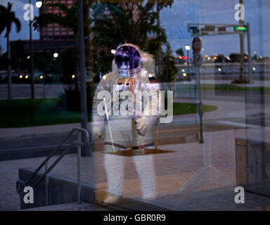 West Palm Beach, Florida, USA. 7th July, 2016. 083110 (Lannis Waters/The Palm Beach Post) WEST PALM BEACH - An astronaut appears to stride through downtown West Palm Beach as reflections of the waterfront reflect off the glass of the Lake Pavilion at West Palm Beach's Waterfront Commons Park before dawn. The spacesuit is on display as part of the Star Gazer exhibition at the pavillion through September 19. SCR 2863 © Lannis Waters/The Palm Beach Post/ZUMA Wire/Alamy Live News