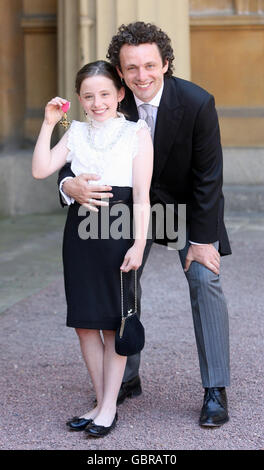 Actor Michael Sheen and daughter Lily with the OBE he received earlier from Queen Elizabeth II during investitures at Buckingham Palace. Stock Photo