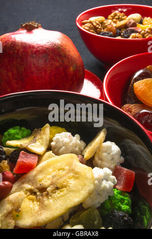 various dried and fresh fruits and mixed nuts on the black background Stock Photo