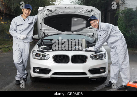 Auto repair personnel in the maintenance of automobile Stock Photo