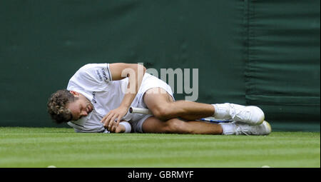 France's Julien Benneteau lies injured during the 2009 Wimbledon Championships at the All England Lawn Tennis and Croquet Club, Wimbledon, London. Stock Photo