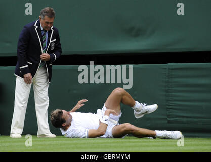 France's Julien Benneteau lies injured during the 2009 Wimbledon Championships at the All England Lawn Tennis and Croquet Club, Wimbledon, London. Stock Photo