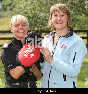 Sergeant Tracy Reid, of Strathclyde Police hands over Copper a nine week old Cocker Spaniel, to Claire Guest Director of Operations from the charity Cancer & Biodetection Dogs, at the Scottish Police Dog Training Centre, Pollock Country Park. Stock Photo