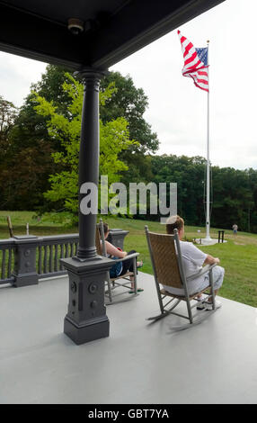 Couple sitting on porch at Sagamore Hill in Cove Neck, NY