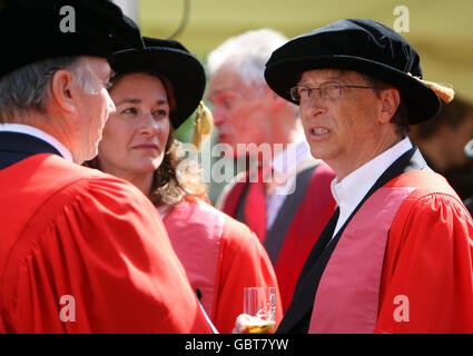 Founder of The Microsoft Corporation Bill Gates (right) with his wife Melinda Gates at the Senate House at Cambridge University, after being made an honorary Doctor of Law during a ceremony at the University. Gates broke with tradition when he collected his degree in an open-necked shirt. Stock Photo