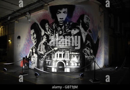 A graffiti artist puts the finishing touches to a piece of work on the walls of the loading bay of the Royal Albert Hall in London, which will make up part of the exhibition 'Load'. Stock Photo