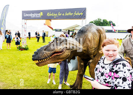 Velociraptor prehistoric dinosaur Jurassic park costume with man inside scaring people UK England GB Stock Photo