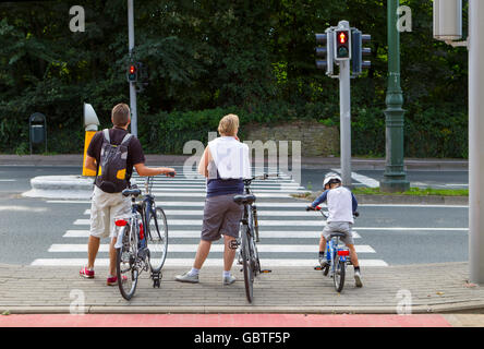 family people waiting cross road bikes bicycles Stock Photo