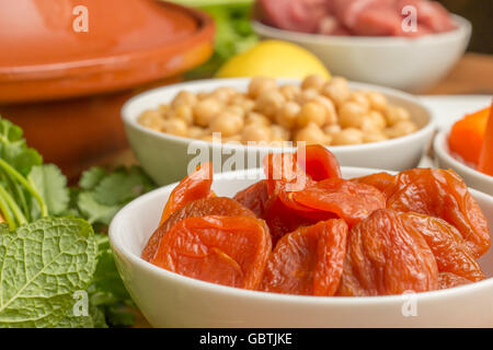 Ingredients for a Moroccan tagine dish with dried apricots, chick peas, lamb, mint and lemon Stock Photo