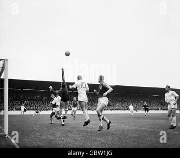 West Ham United goalkeeper Lawrie Leslie (third l) punches clear from Manchester United's Mark Pearson (10), watched by teammates Ken Brown (l), Bobby Moore (fourth l) and Joe Kirkup (second r), and Manchester United's David Herd (r) and Dennis Viollet (second l) Stock Photo