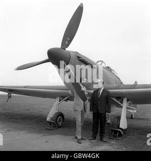 Flight Lt. James 'Ginger' Lacey, right, and Wing Commander Robert Stanford-Tuck stand next to a British Hurricane fighter at RAF Henlow, Buckinghamshire. The two veterans, along with many British and German aircraft from WWII, are part of the epic film being made both here and across Europe, 'The Battle of Britain' Stock Photo