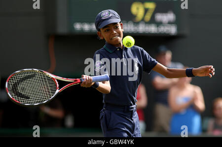 A ball boy plays on court one after France's Michael Llodra retires through injury during his match against Germany's Tommy Haas Stock Photo