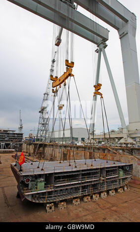 The first part of the keel of the Cunard Line's newest cruise ship, Queen Elizabeth, is lifted into the dry dock at Monfalcone Shipyard in Trieste, Italy. Stock Photo