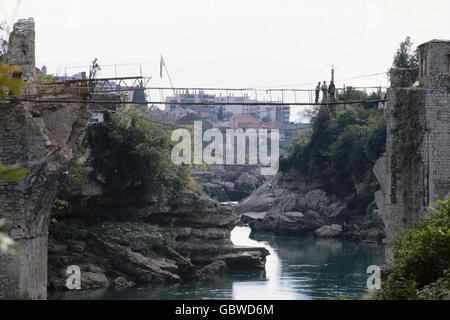 events, Bosnian War 1992 - 1995, Mostar, provisional suspension bridge over river Neretva, 1994, Bosnia-Herzegovina, Bosnia - Herzegovina, destruction, destroyed bridge, flag, Yugoslavia, Yugoslav Wars, Balkans, conflict, people, 1990s, 90s, 20th century, historic, historical, Additional-Rights-Clearences-Not Available Stock Photo