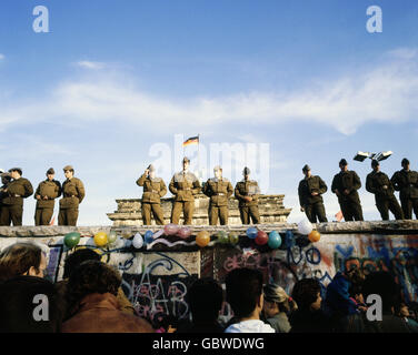 geography / travel, Germany, Fall of the Berlin Wall, soldiers standing on the Wall, in front of the Brandenburg Gate, Berlin, December 1989, historic, historical, 20th century, 1980s, 80s, opening, down, November'89, November 89, East Germany, East-Germany, German border, NVA border patrol, soldier, people, male, man, men, Additional-Rights-Clearences-Not Available Stock Photo