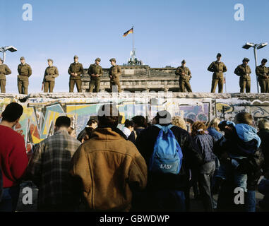 geography / travel, Germany, Fall of the Berlin Wall, soldiers standing on the Wall, in front of the Brandenburg Gate, Berlin, December 1989, historic, historical, 20th century, 1980s, 80s, opening, down, November'89, November 89, East Germany, East-Germany, German border, NVA border patrol, soldier, people, male, man, men, Additional-Rights-Clearences-Not Available Stock Photo