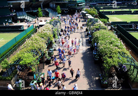 Crowds run in before play starts during the Wimbledon Championships at the All England Lawn Tennis and Croquet Club, Wimbledon, London. Stock Photo