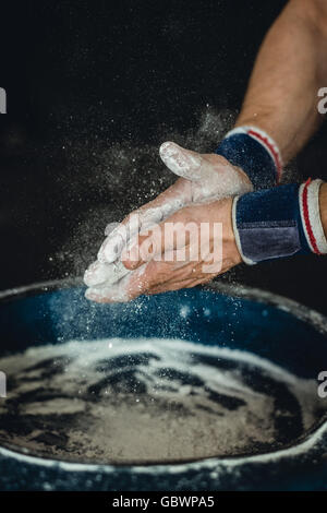 Preparing hands with chalk before beginning calisthenics, gymnastics fitness training. Stock Photo