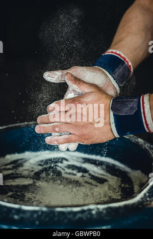 Preparing hands with chalk before beginning calisthenics, gymnastics fitness training. Stock Photo