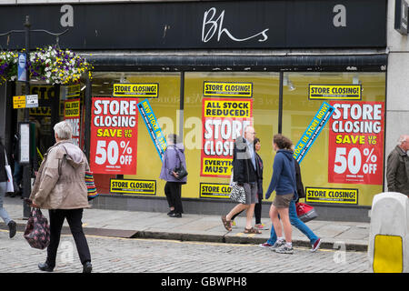 Shoppers outside British Home Stores shop in Cornwall, England, with closing down sale posters. Stock Photo
