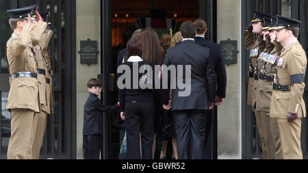 Friends and family of Major Sean Birchall of the 1st Battalion Welsh Guards follow his coffin into the Guards Chapel, London, for his funeral service. Stock Photo