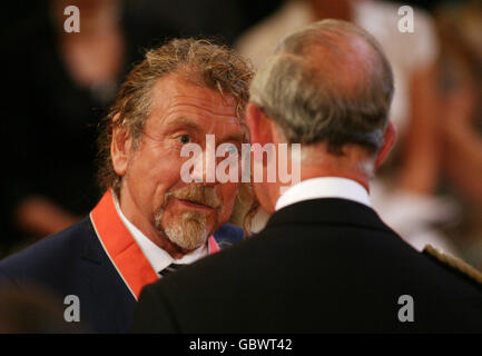 Former Led Zeppelin frontman Robert Plant receives his CBE from the Prince of Wales during the investiture ceremony at Buckingham Palace. Stock Photo