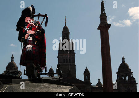 A piper stands on a tank in George Sq as the Royal Scots Dragoon Guards parade through the city of Glasgow after returing from Iraq. Stock Photo