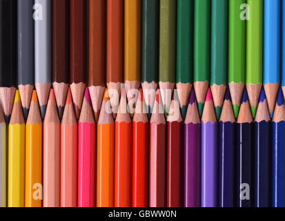 Background of colored pencils forming a color palette with the tips facing aligned. Top view. Stock Photo