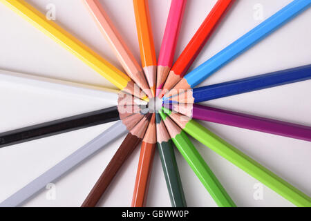 Background detail with gradient color pencils placed on circle on white table. Top view Stock Photo