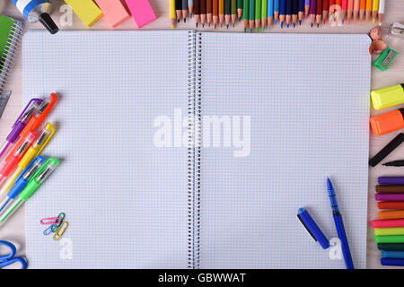 Background with school or office material with open notebook with checkered sheets in the center and space for title. Top view Stock Photo