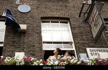 Natalie Cassidy and James Alexandrou peer from a window during an English Heritage Plaque unveiling for Eastenders actress Wendy Richard, at Shepherd's Tavern on 50 Hertford Street, Mayfair, central London. Stock Photo