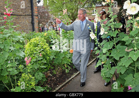 The Prince of Wales, centre, patron of the Almshouse Association, walks through an allotment during a visit to St Pancras almshouses in north London to celebrate the 150th anniversary of the Almshouses. Stock Photo