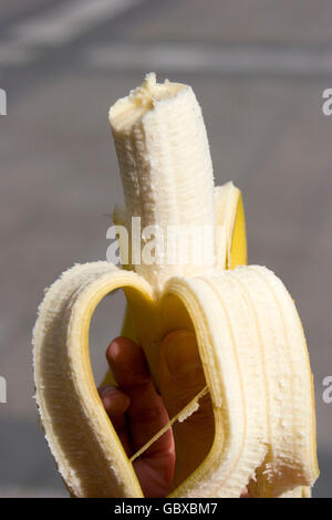 Woman holding a half-eaten banana Stock Photo