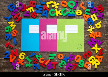 Three exercise books and border of colorful letters and numbers Stock Photo