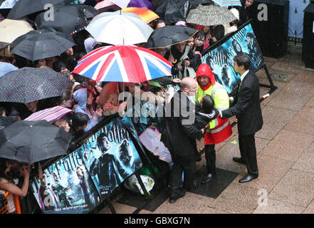 A fan is removed from the crowd during heavy rain at the world premiere of Harry Potter and the Half-Blood Prince at the Odeon Leicester Square, London. Stock Photo