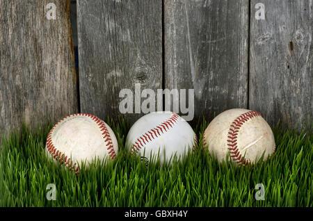 Three baseballs on green grass with room for your type. Stock Photo
