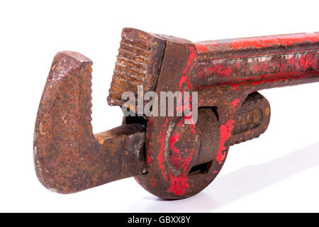Vertical upright old neglected rusty well used red monkey wrench spanner Stock Photo