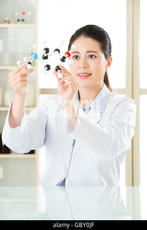 asian female scientist Examining the building blocks of life with molecular model in laboratory Stock Photo