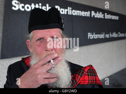 Robert Brodie takes a break outside the Scottish Parliament in Edinburgh at the Clan Convention. One hundred of Scotland's Clan Chiefs will gather for a Clan Convention as part of the Gathering weekend in the city. Stock Photo