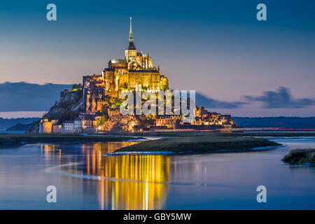 Classic view of famous Le Mont Saint-Michel tidal island in beautiful twilight during blue hour at dusk, Normandy, France