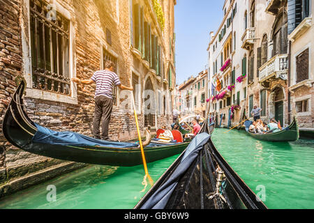 Gondolas on canal in Venice, Italy with retro vintage Instagram style filter and lens flare sunlight effect in summer Stock Photo